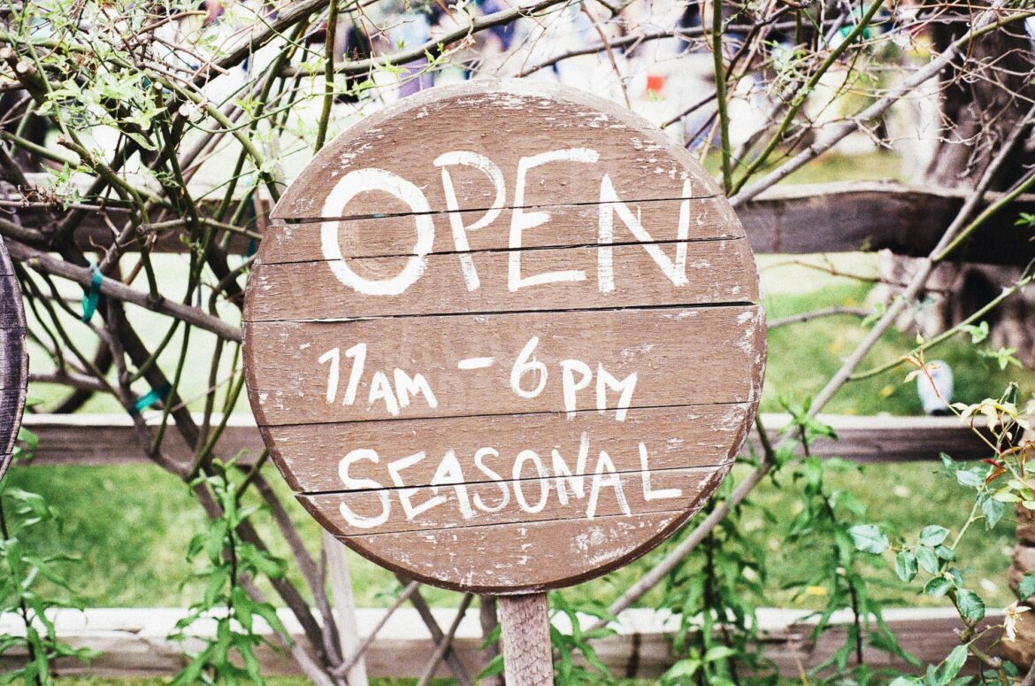 Wooden open sign with seasonal hours