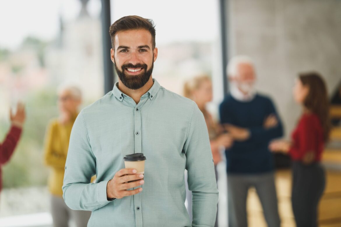 Smiling business owner standing in a busy office